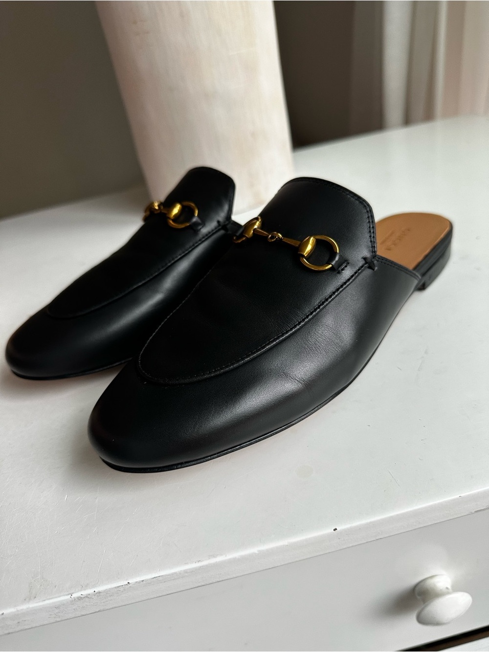 Gucci black leather backless loafer mules featuring the iconic gold-tone Horsebi